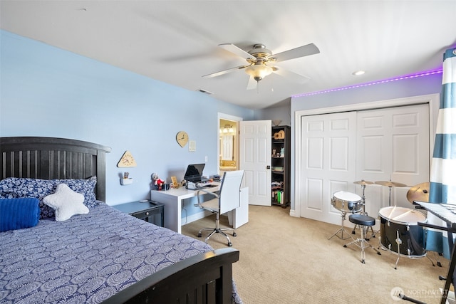 carpeted bedroom featuring ceiling fan, visible vents, and a closet