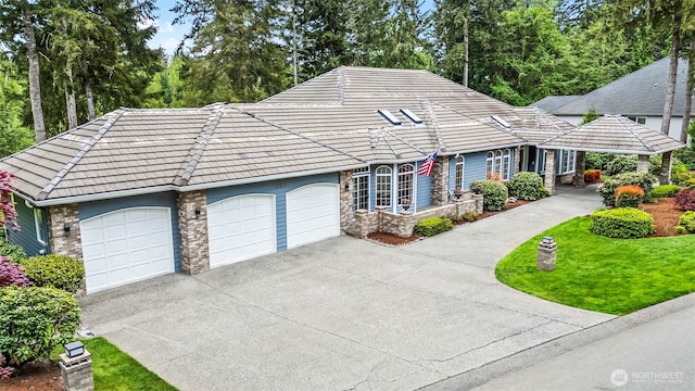 13311 Foxglove Dr NW, Gig Harbor, WA 98332 - view of front facade with a tile roof, a front yard, a garage, concrete driveway, and stone siding