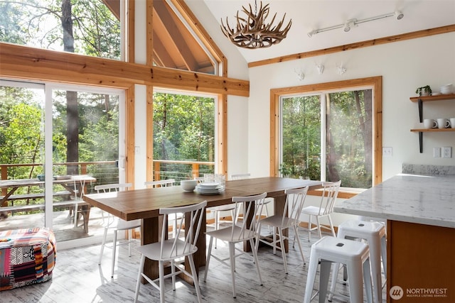 sunroom / solarium with a notable chandelier and rail lighting