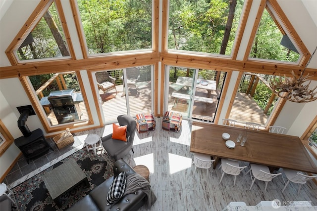 sunroom / solarium featuring a wooden deck, plenty of natural light, and a wood stove
