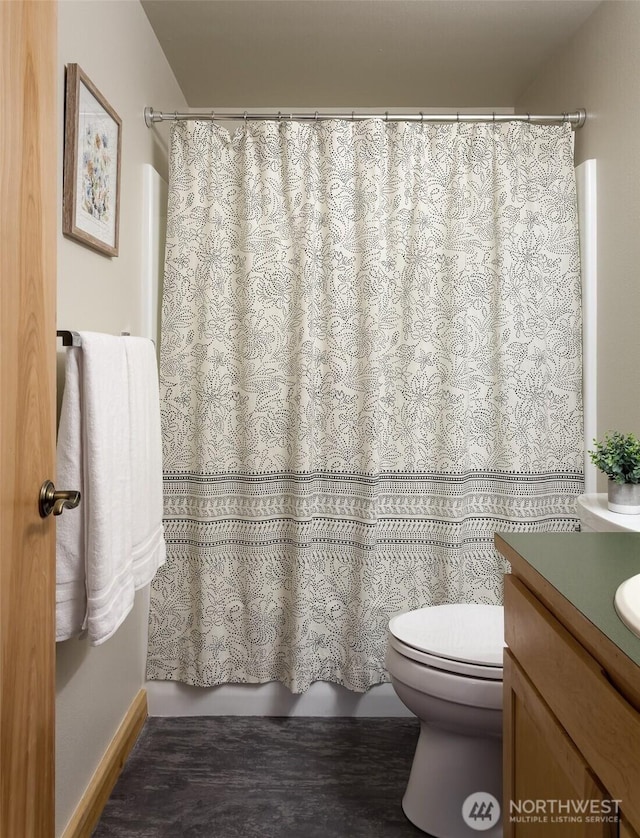 bathroom featuring baseboards, toilet, and vanity