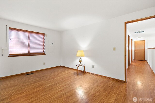 unfurnished room featuring visible vents, baseboards, and wood finished floors