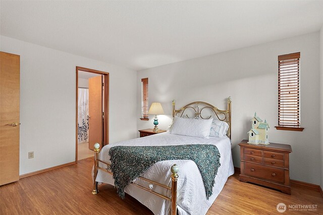 bedroom featuring baseboards and wood finished floors