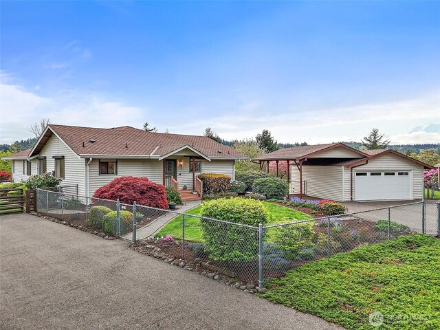 single story home featuring an attached garage, driveway, and a fenced front yard