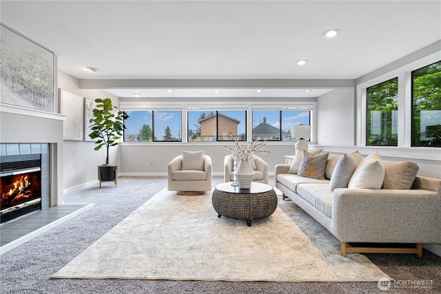 living room featuring recessed lighting, plenty of natural light, a tiled fireplace, and carpet