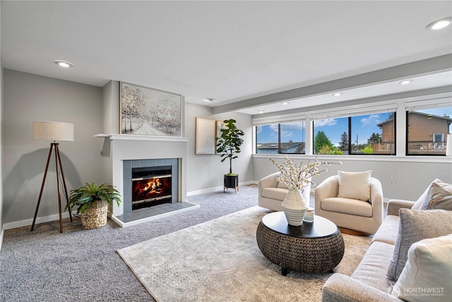 carpeted living room featuring baseboards, recessed lighting, and a tile fireplace