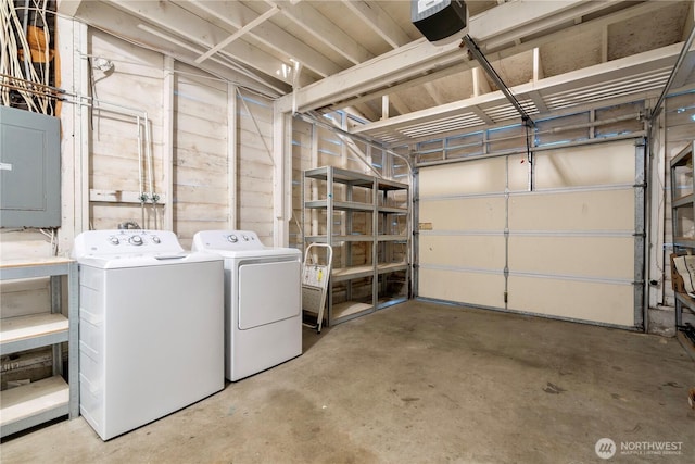 laundry area featuring washer and dryer, a garage, laundry area, and electric panel