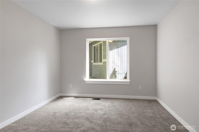 unfurnished room with carpet, visible vents, and baseboards