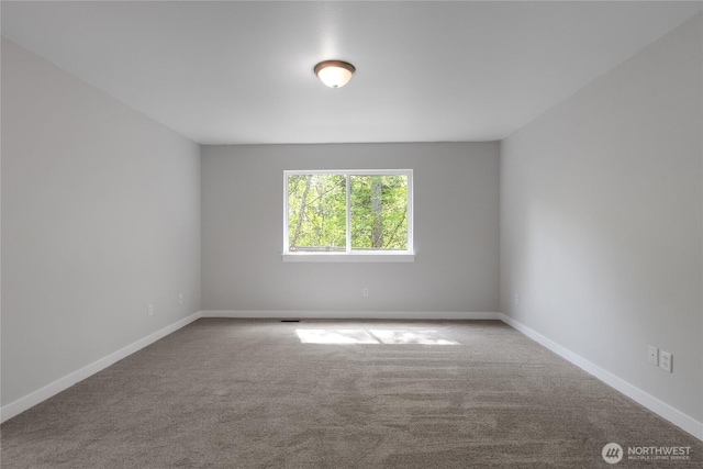 empty room featuring carpet and baseboards