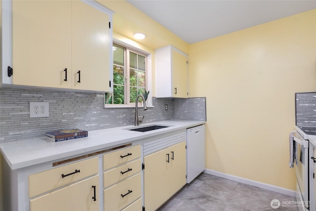 kitchen featuring baseboards, a sink, decorative backsplash, and dishwasher