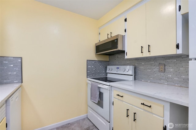 kitchen featuring baseboards, decorative backsplash, light stone counters, and white appliances