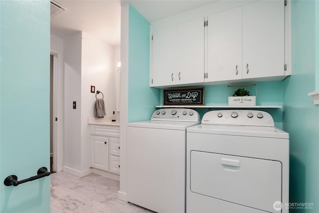 clothes washing area with baseboards, washing machine and dryer, cabinet space, and marble finish floor