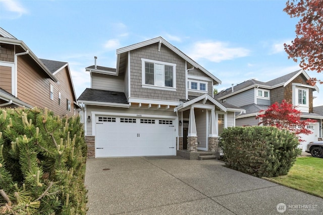 craftsman-style house featuring an attached garage, concrete driveway, and stone siding