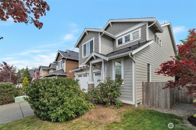 view of side of home with an attached garage and fence