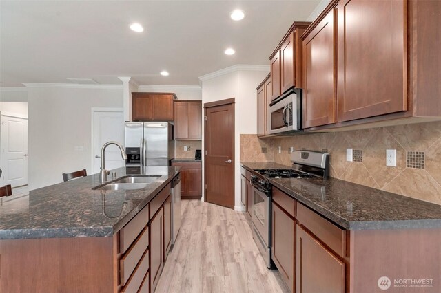 kitchen featuring a sink, appliances with stainless steel finishes, crown molding, and light wood-style floors