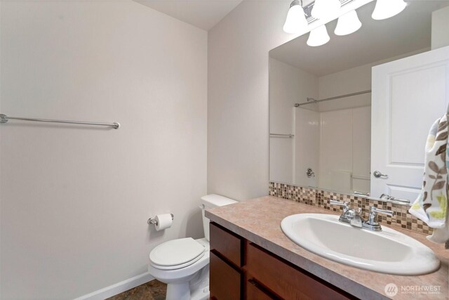 full bath featuring backsplash, walk in shower, baseboards, vanity, and toilet