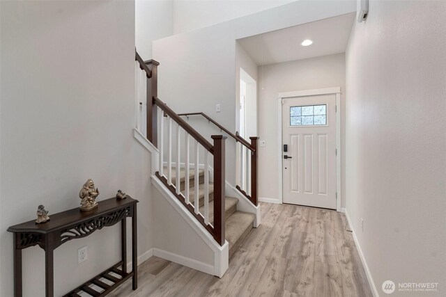 entrance foyer featuring baseboards, stairs, and wood finished floors