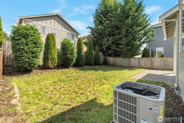 view of yard with central AC unit, a fenced backyard, and a patio area