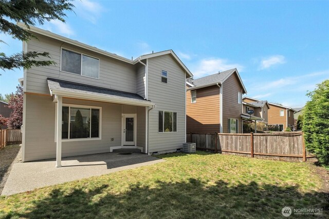 back of property with fence, central air condition unit, a yard, and a patio area