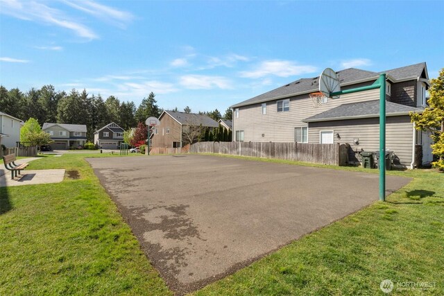 exterior space with a lawn, fence, and a residential view