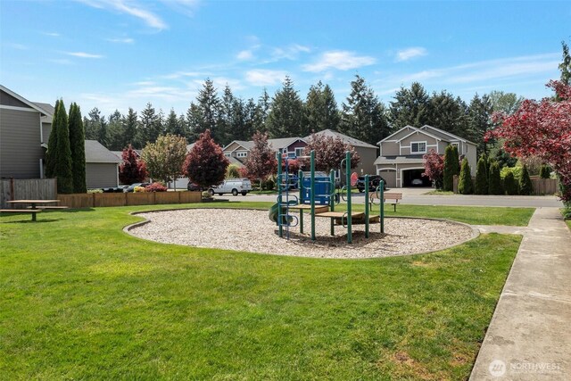 community playground featuring a yard and fence