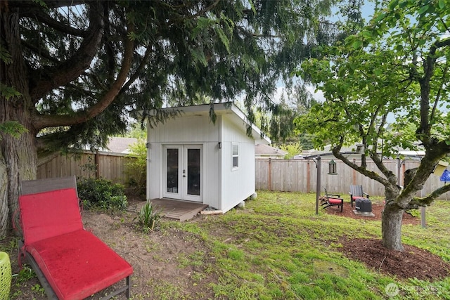 back of house featuring an outdoor structure and french doors