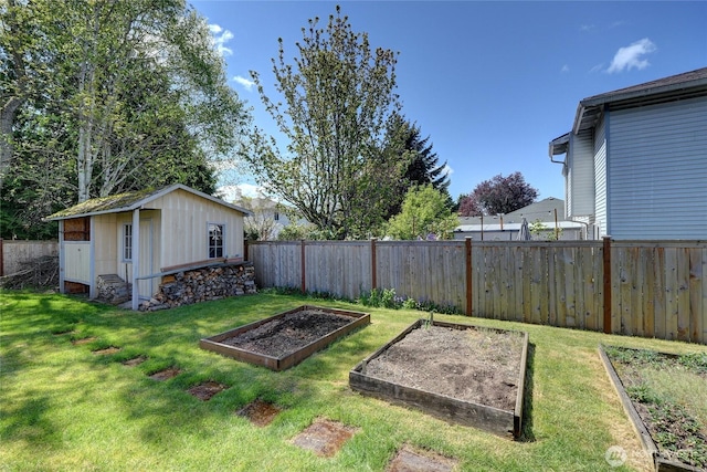 view of yard featuring a fenced backyard, an outbuilding, and a vegetable garden
