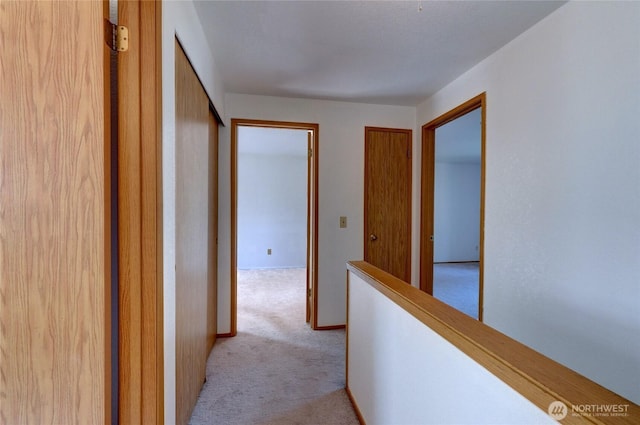 hallway featuring light carpet and an upstairs landing