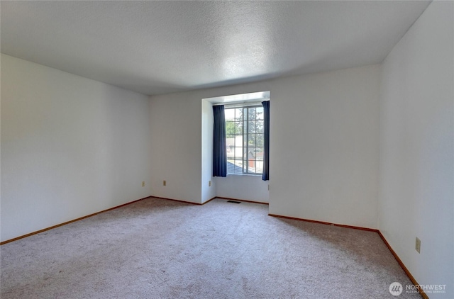 unfurnished room with carpet flooring, baseboards, and visible vents