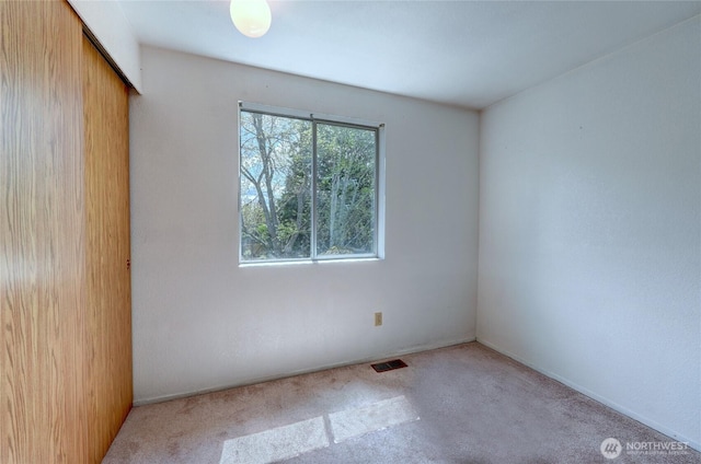 spare room featuring carpet floors and visible vents
