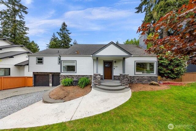 1626 106th Ave SE, Bellevue, WA 98004 - view of front of house featuring driveway, fence, a garage, stone siding, and a front lawn