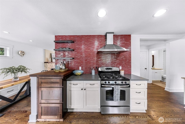 1626 106th Ave SE, Bellevue, WA 98004 - kitchen featuring stainless steel gas range, wall chimney exhaust hood, dark wood-type flooring, dark countertops, and white cabinets