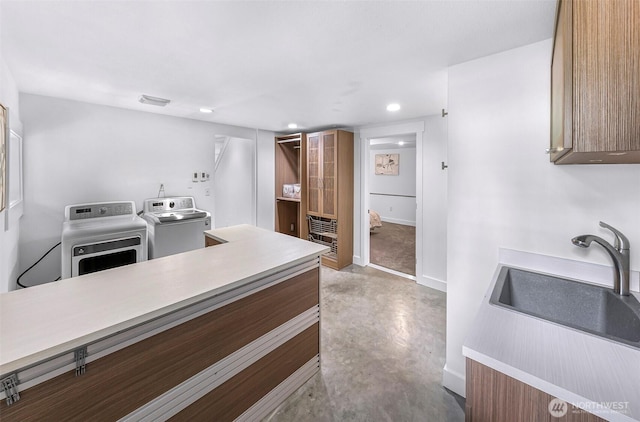 1626 106th Ave SE, Bellevue, WA 98004 - kitchen with a sink, separate washer and dryer, concrete flooring, baseboards, and recessed lighting