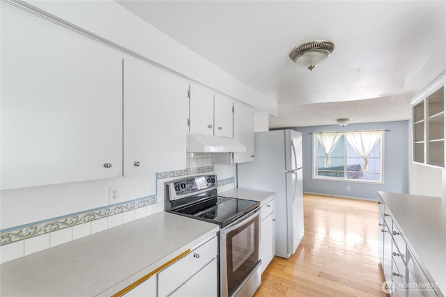 kitchen with stainless steel range with electric stovetop, light countertops, under cabinet range hood, white cabinets, and light wood-style flooring