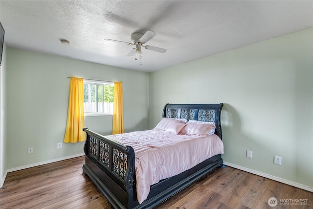 bedroom with a ceiling fan, baseboards, wood finished floors, and a textured ceiling