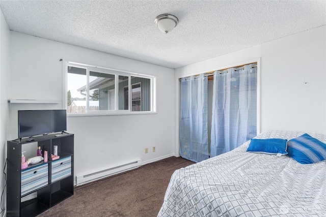 bedroom featuring a textured ceiling, a baseboard heating unit, and carpet