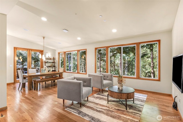 living room with baseboards, vaulted ceiling, recessed lighting, and light wood-style flooring