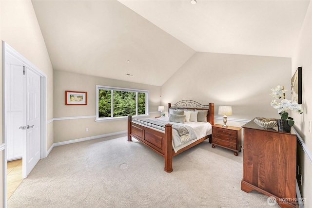 bedroom featuring light colored carpet, vaulted ceiling, and visible vents