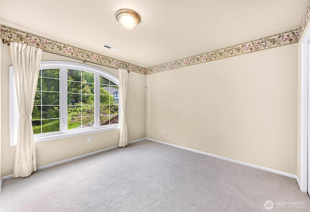 carpeted spare room featuring baseboards and visible vents