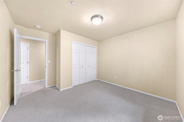unfurnished bedroom with carpet floors, baseboards, and a closet