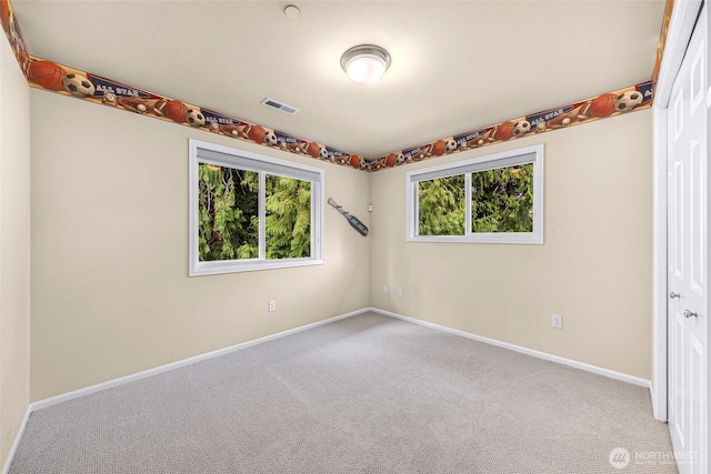 carpeted spare room with visible vents and baseboards