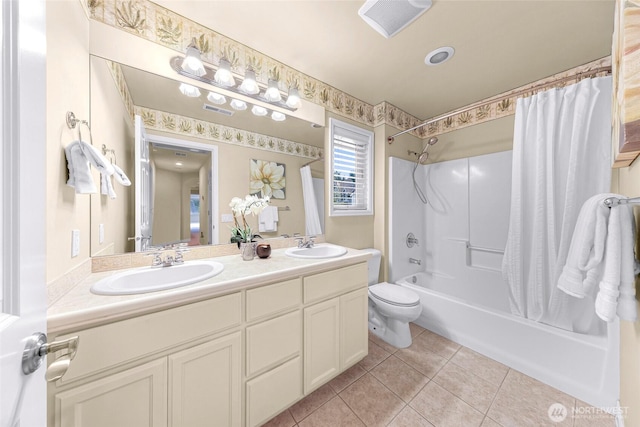 full bath featuring double vanity, shower / bath combo, a sink, tile patterned floors, and toilet