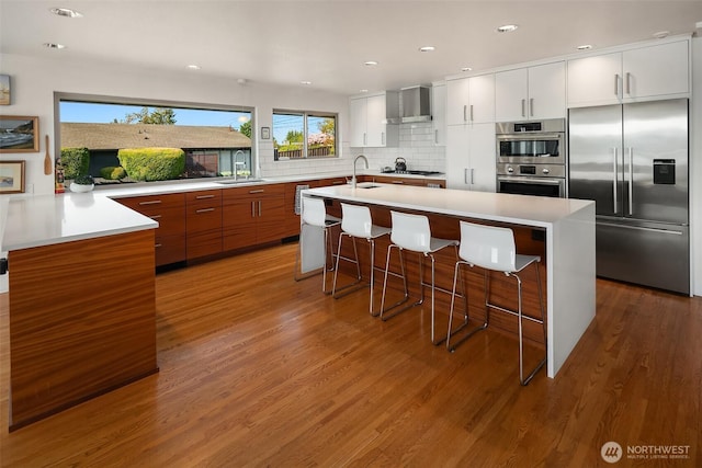 6614 N 49th St, Tacoma, WA 98407 - kitchen with modern cabinets, stainless steel appliances, wall chimney exhaust hood, and wood finished floors
