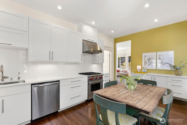 514 30th Ave E, Seattle, WA 98112 - kitchen with under cabinet range hood, stainless steel appliances, decorative backsplash, and a sink