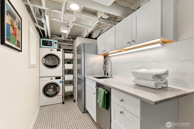 514 30th Ave E, Seattle, WA 98112 - washroom with cabinet space, a sink, stacked washer / dryer, and light floors
