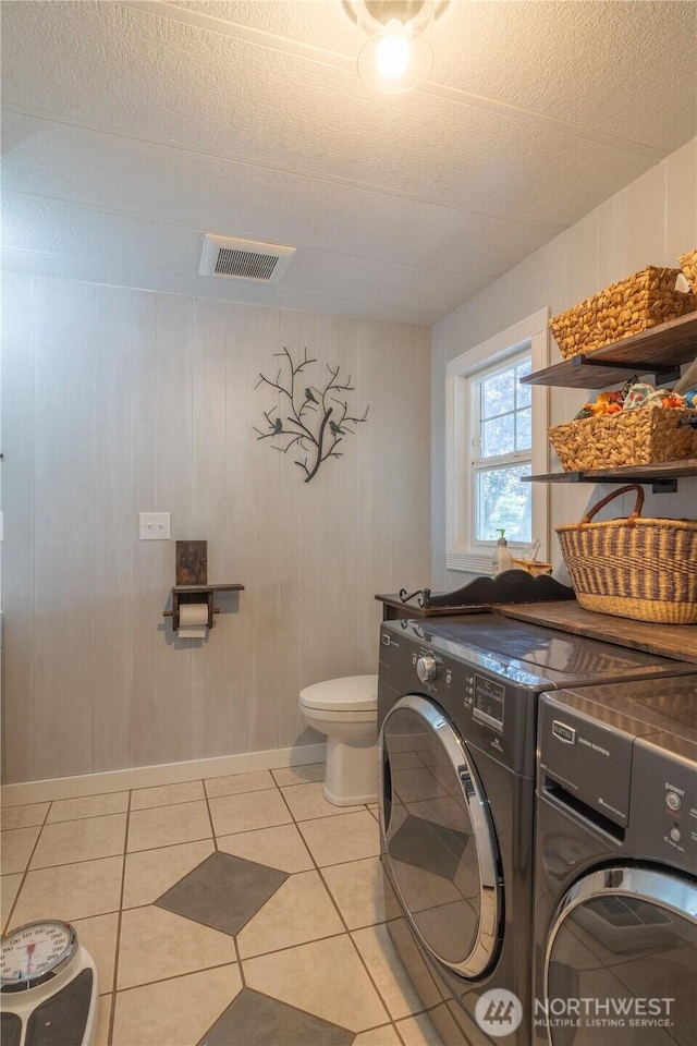 laundry room with visible vents, light tile patterned floors, laundry area, and washing machine and dryer