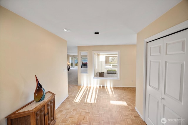 hall with baseboards and recessed lighting