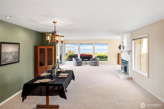 carpeted living area with baseboards, a notable chandelier, and a fireplace