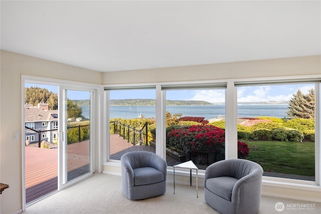 sunroom featuring a water view