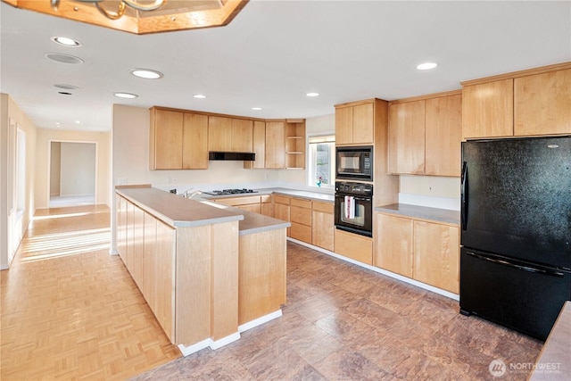 kitchen with a peninsula, under cabinet range hood, black appliances, and light brown cabinets